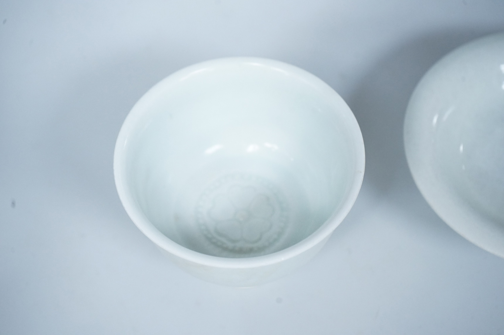 A Chinese white glazed stem cup and similar dish, tallest 7cm